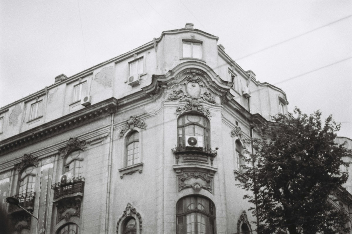 Fațadă ornamentată a unei clădiri vechi, în alb-negru