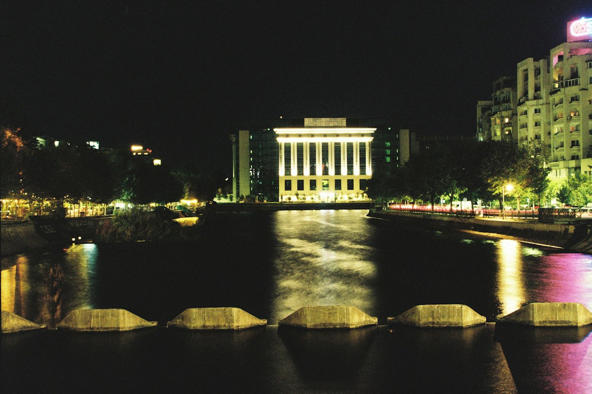 Clădire luminată noaptea, lângă apă