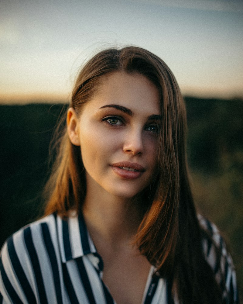 Femeie cu machiaj simplu și natural, în lumină caldă