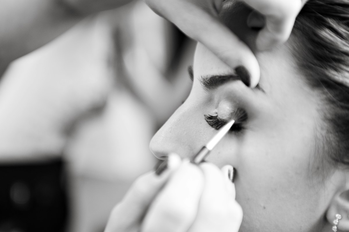 Makeup artist care aplică tuș, fotografie alb-negru