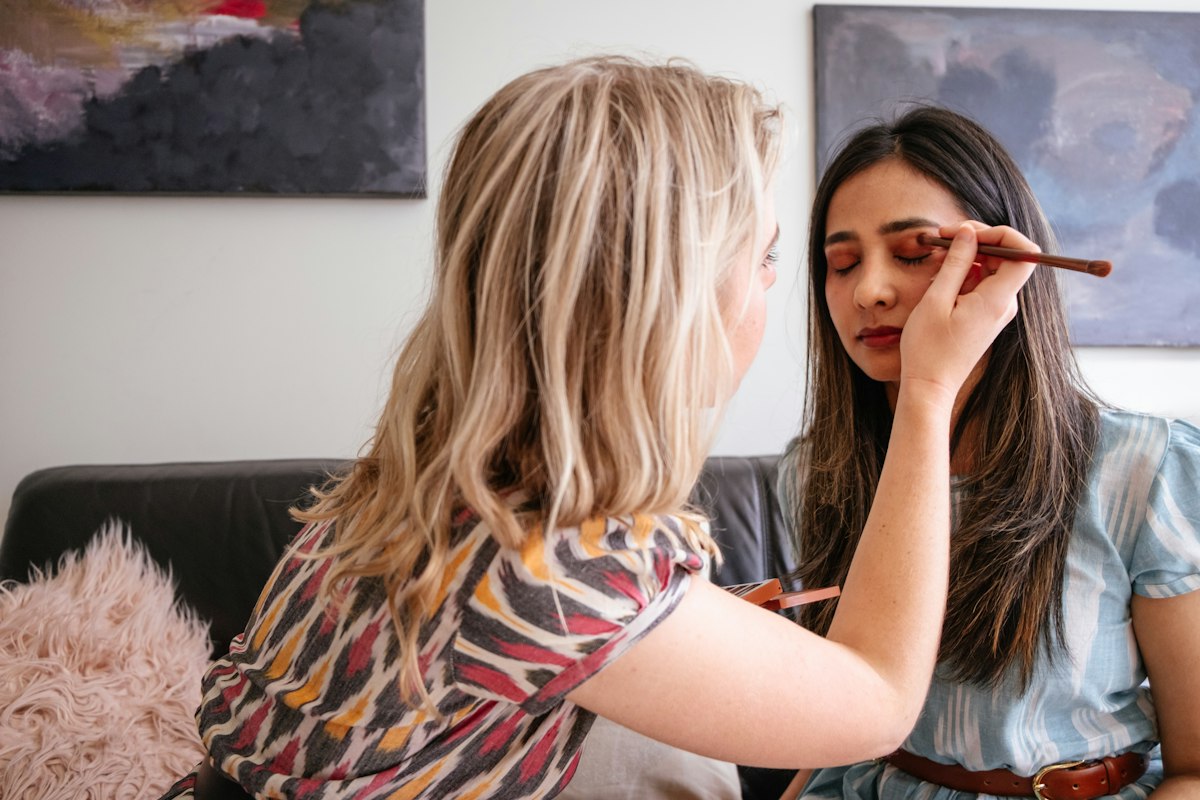 Makeup artist care machiază o clientă acasă